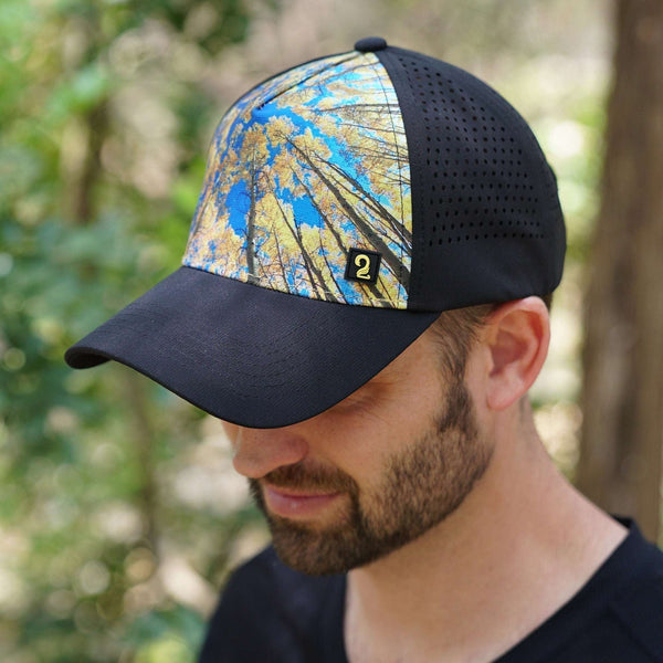 Mens trucker hats with blue and yellow forest canopy design, breathable black mesh back, and moisture-wicking bamboo headband for outdoor adventure comfort