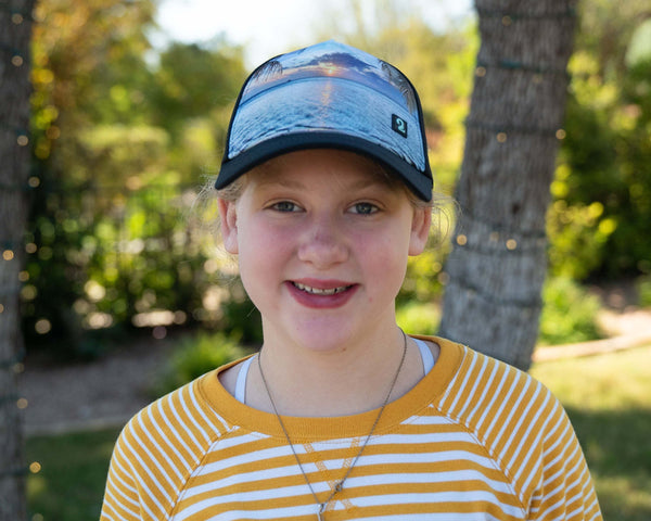 Youth Girls Trucker Hat with high ponytail opening featuring water-resistant material and scenic print, perfect for girls ages 4-10, Seas the Day design