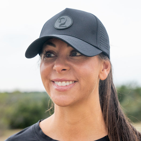 Black female trucker ponytail hat with breathable, water-resistant material and moisture-wicking bamboo headband for outdoor adventures