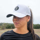 Woman wearing white Aoraki ponytail trucker hat with breathable panels outdoors