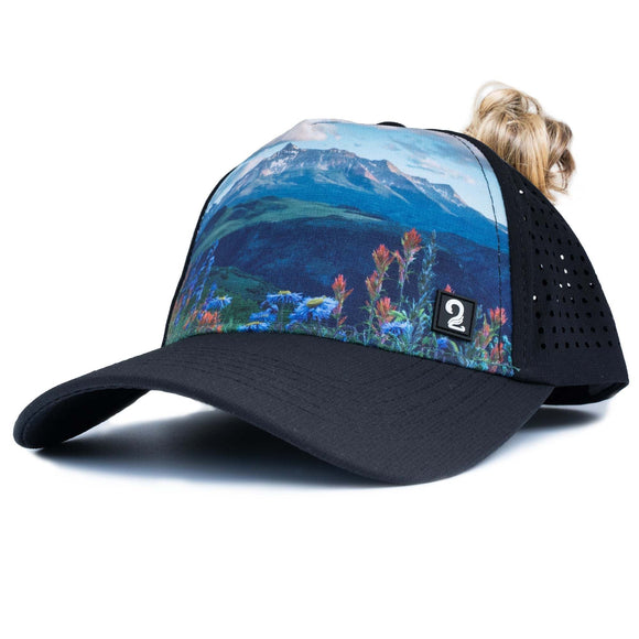 Female trucker hat with mountain and flower design, high ponytail opening, breathable and water-resistant material for outdoor adventures