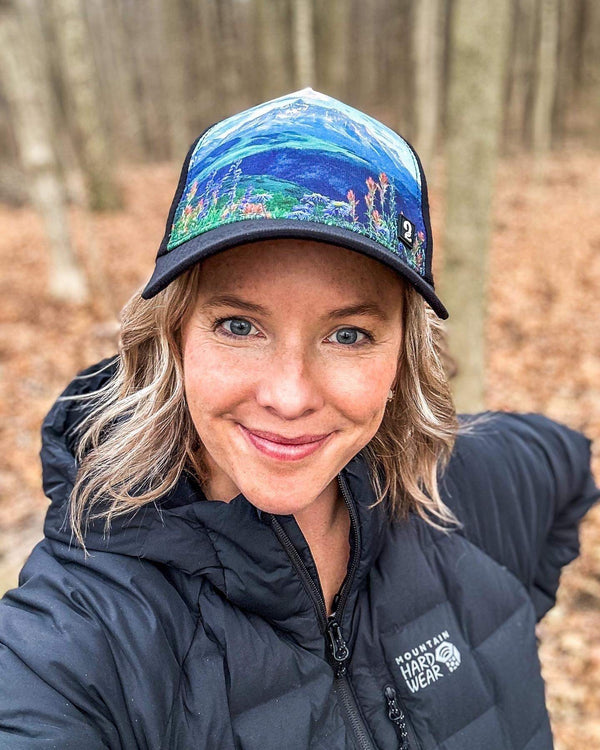 Female trucker hat with high ponytail opening and mountain scenic design, breathable and water-resistant for outdoor adventures