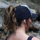 Female trucker hat with high ponytail opening, breathable and water-resistant for outdoor adventures