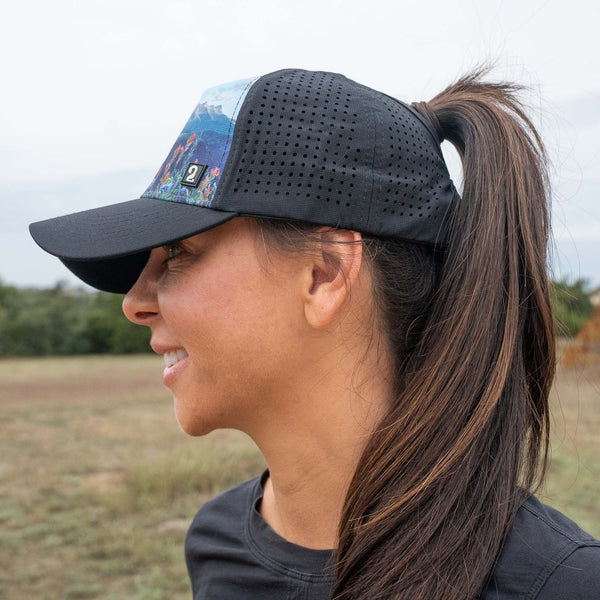 Female trucker hat with high ponytail opening and breathable water-resistant design for outdoor adventures